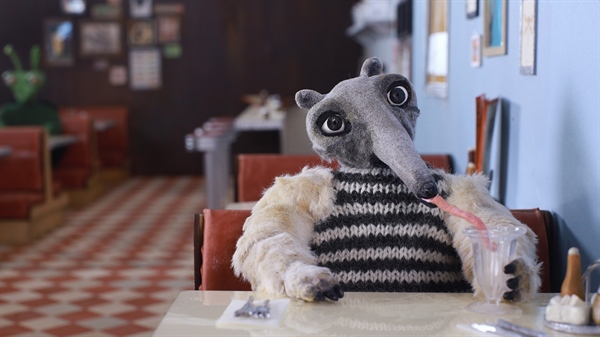 Stop-motion animation of an ant eater sitting at a diner