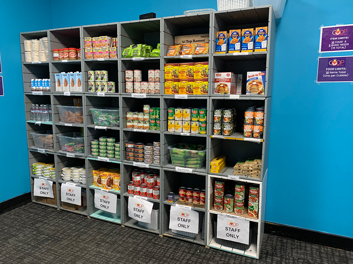 Large gray shelf with 36 cubbies stocked with many different kinds of packaged food.