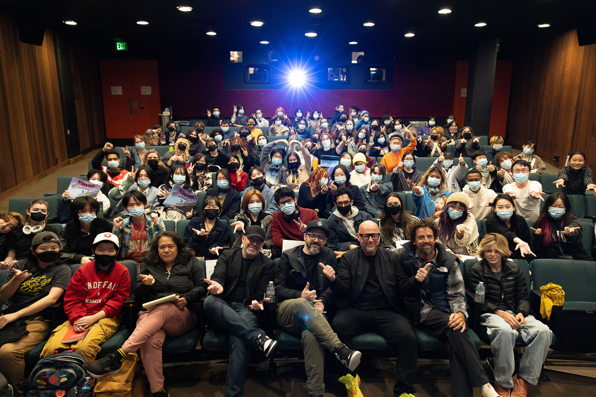 A small theater filled people smiling at the camera 