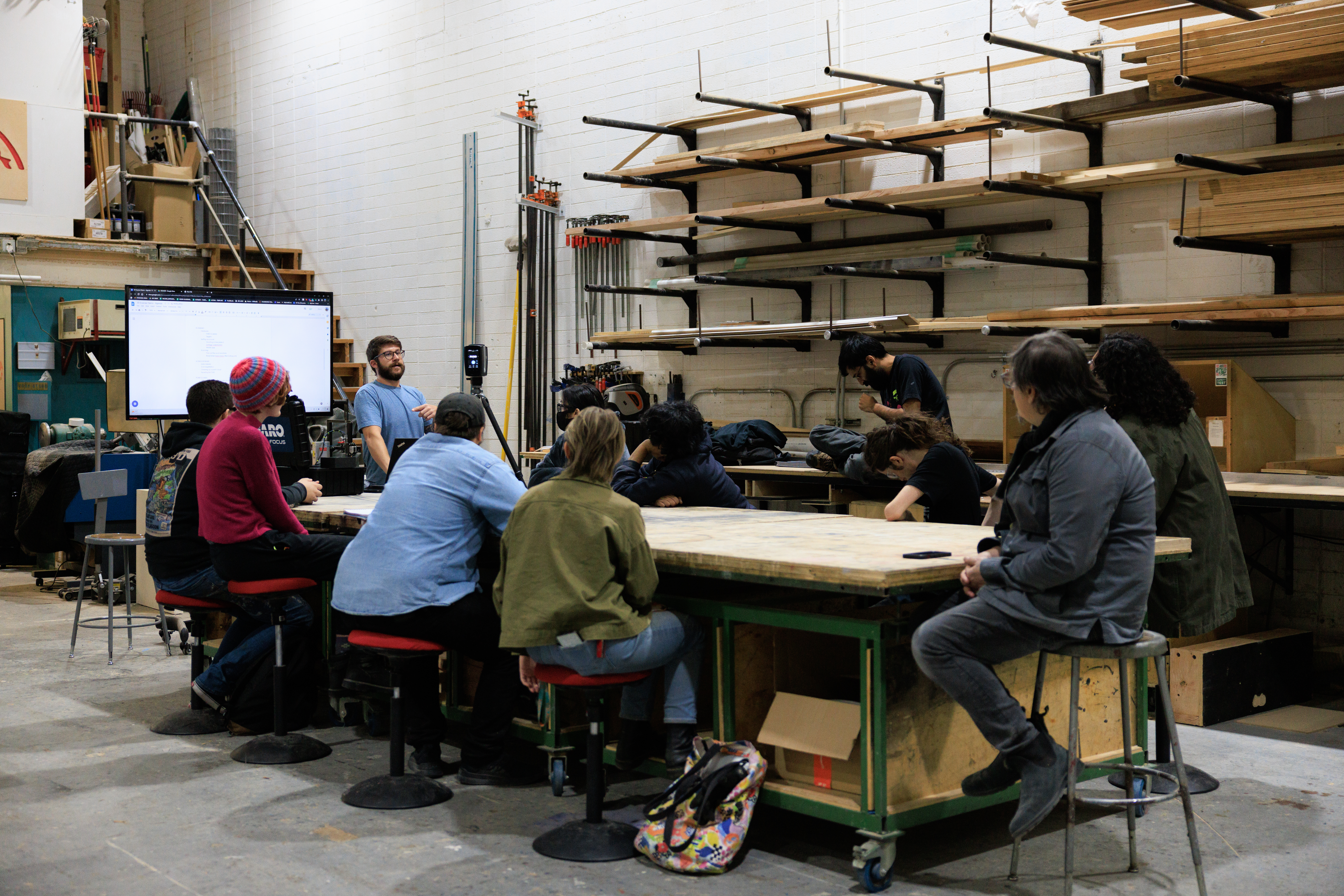 Class meets in the CalArts scene shop, the room is set up like a workshop with supplies like sheets of plywood on the wall.