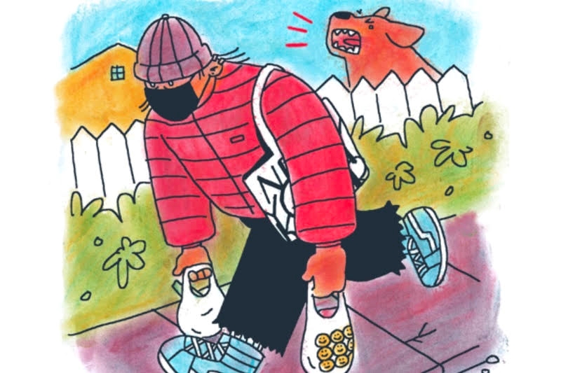 A person in a red puffer jacket, carrying grocery bags, walks past a barking dog behind a picket fence.