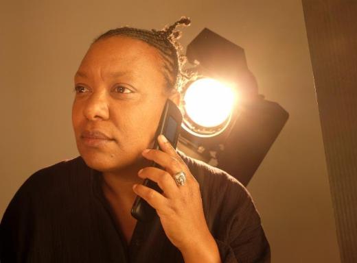 Photo of Meshell Ndegeocello with a bright light behind her