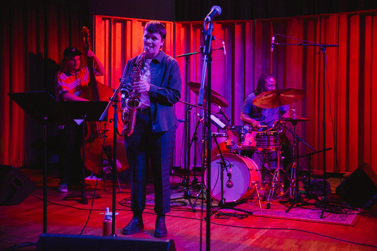 a band performing at calarts, lit by colorful lights