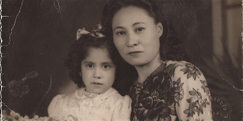 Black and white portrait of two people with a dark background.