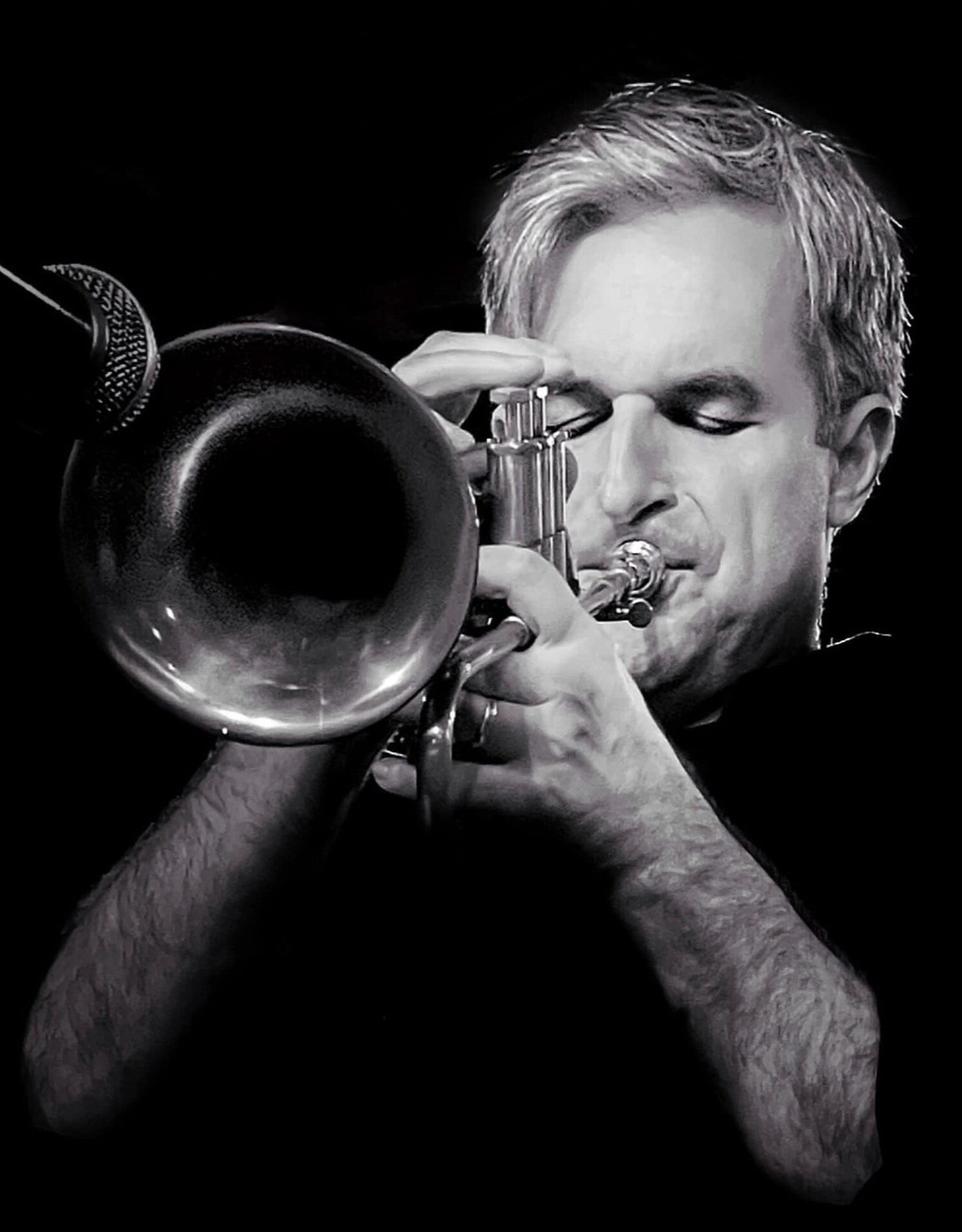 Musician playing a trumpet in a black and white photograph.