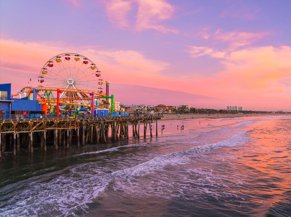 Santa Monica Pier with Ferris wheel at sunset with pink, orange, and purple sky.