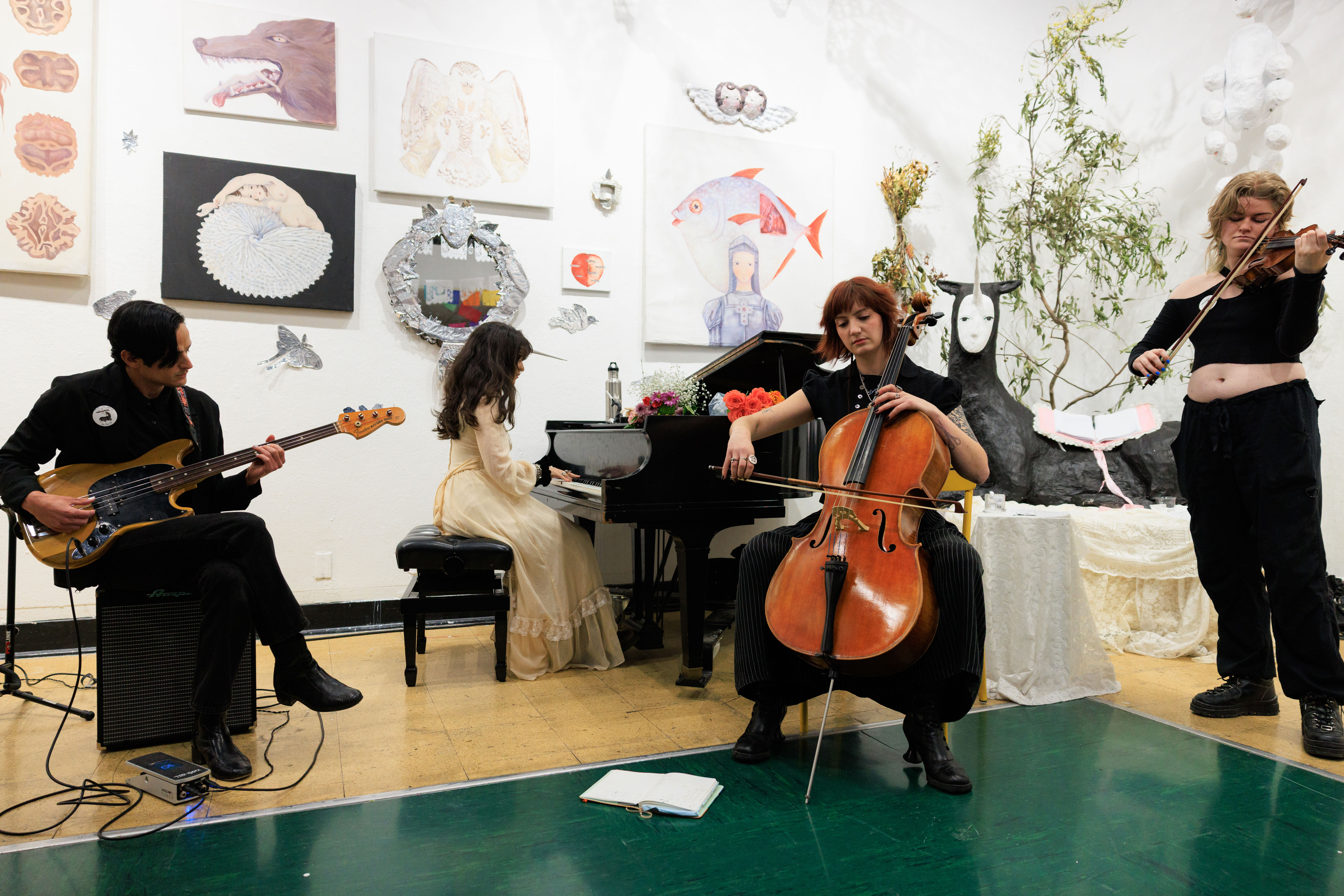 A musical ensemble of four plays in an art gallery, surrounded by paintings and sculptures.