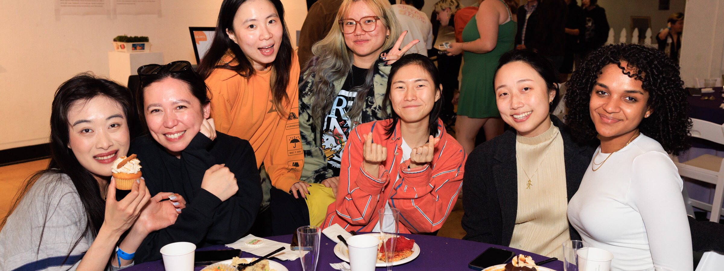 A group of seven students sit at a CalArts mixer