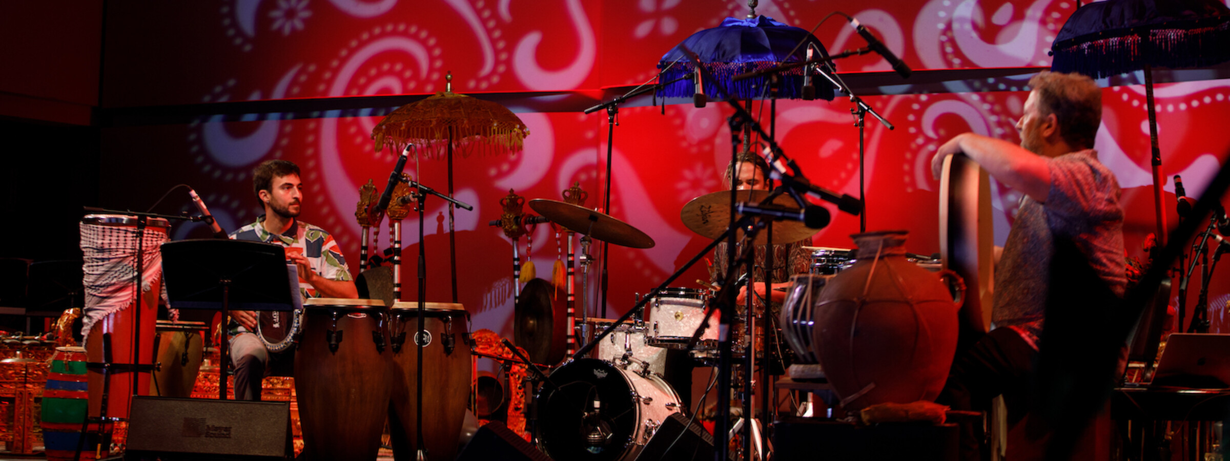 World percussion ensemble performs on a red stage at CalArts