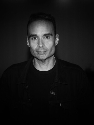 Photo of a man, John Tejada, in a dark room. 