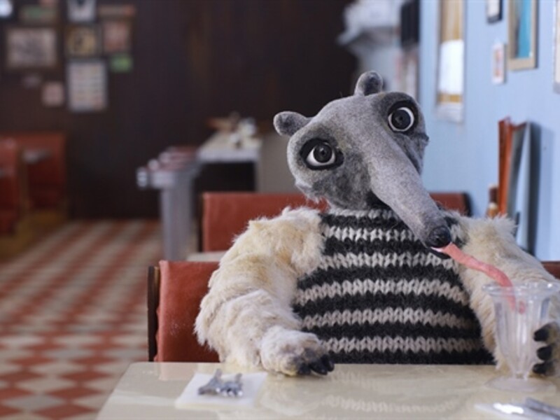 Stop-motion animation of an ant eater sitting at a diner