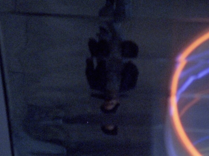 Image of a character looking at their reflection through a puddle on the ground