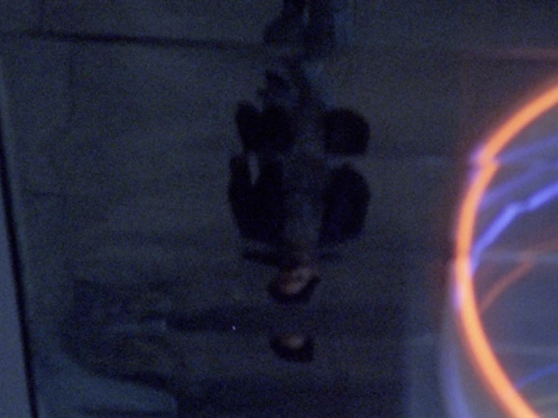 Image of a character looking at their reflection through a puddle on the ground