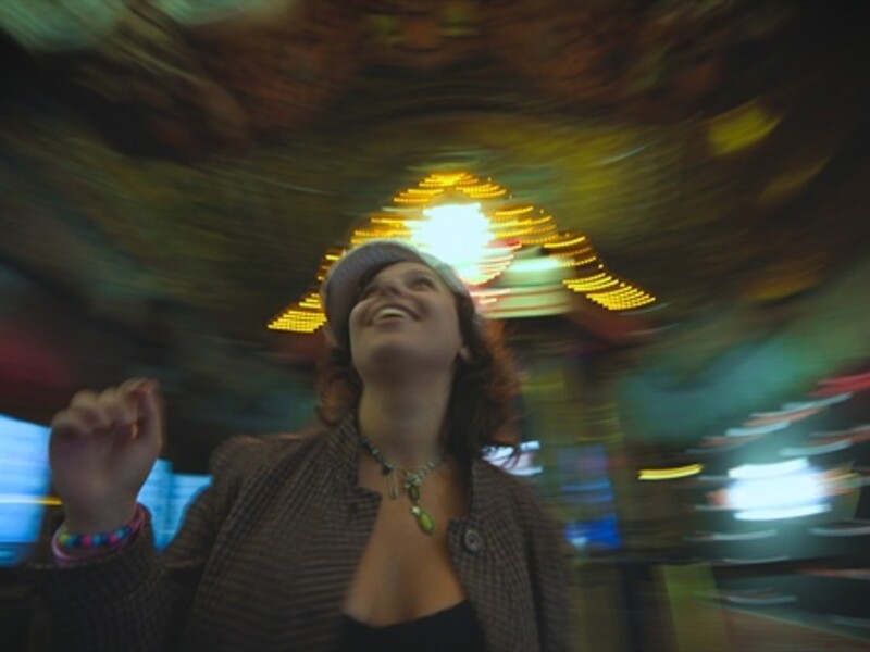 Image of a person smiling while walking through a bright blurry room