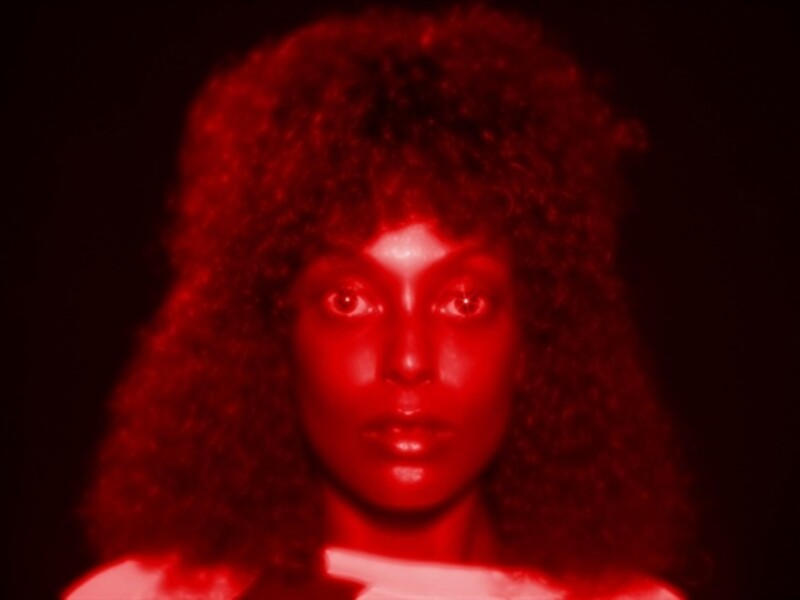 Image of a person with a red design on their face with a black background