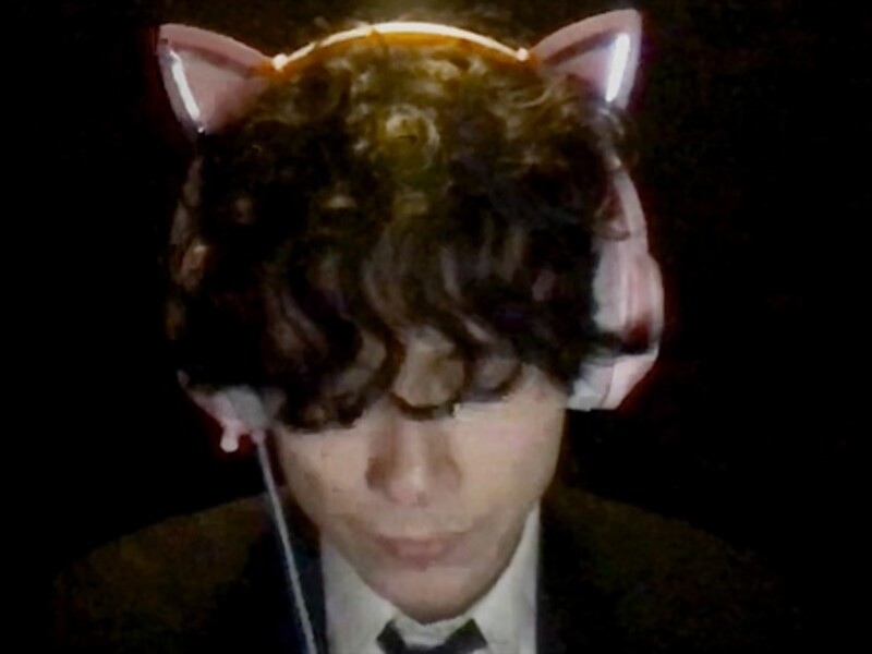 Image of a person in a suit with cat headphones on