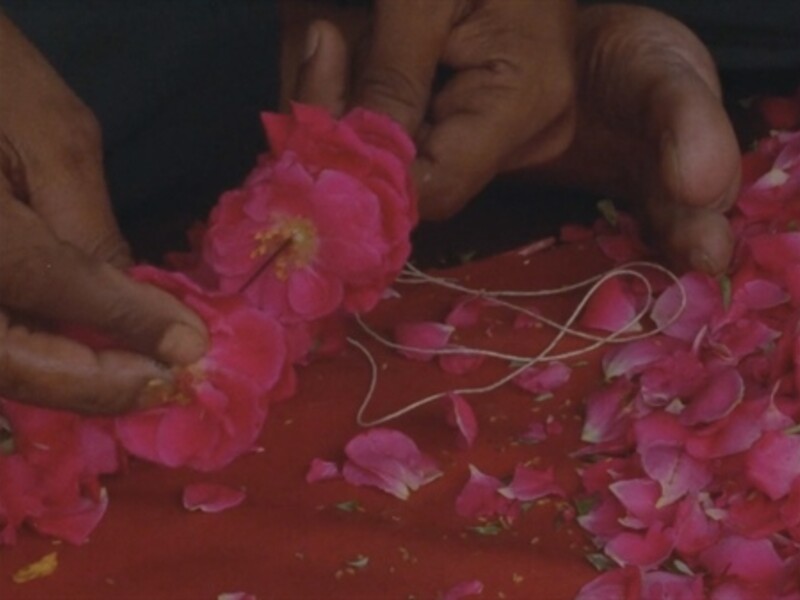 hands putting together a flower necklace