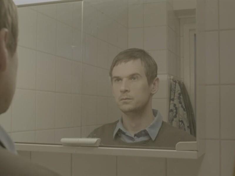 man looking in bathroom mirror