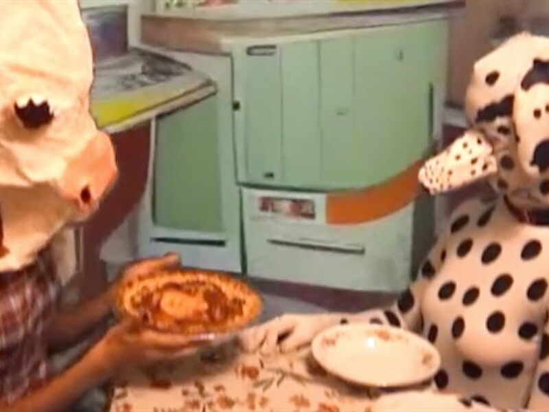 two people in animal costumes sitting at a dinner table