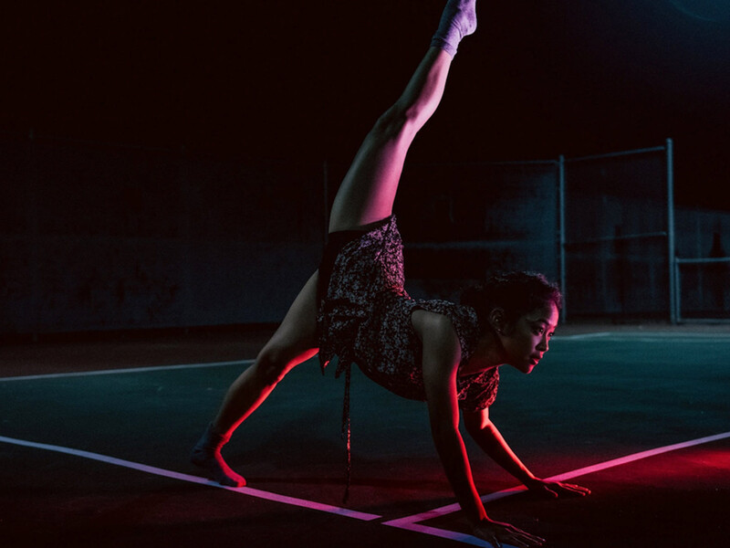 Woman in dancing pose outdoors at night  