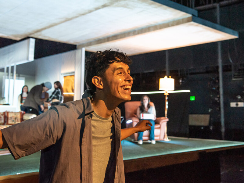 Actor gestures towards the audience with a smile