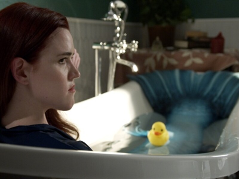 woman sitting in bathtub with rubber ducky