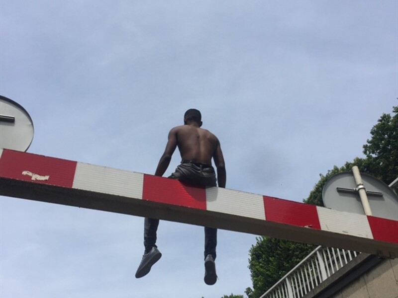 Person sitting on a Red and White Beam Overlooking Paris