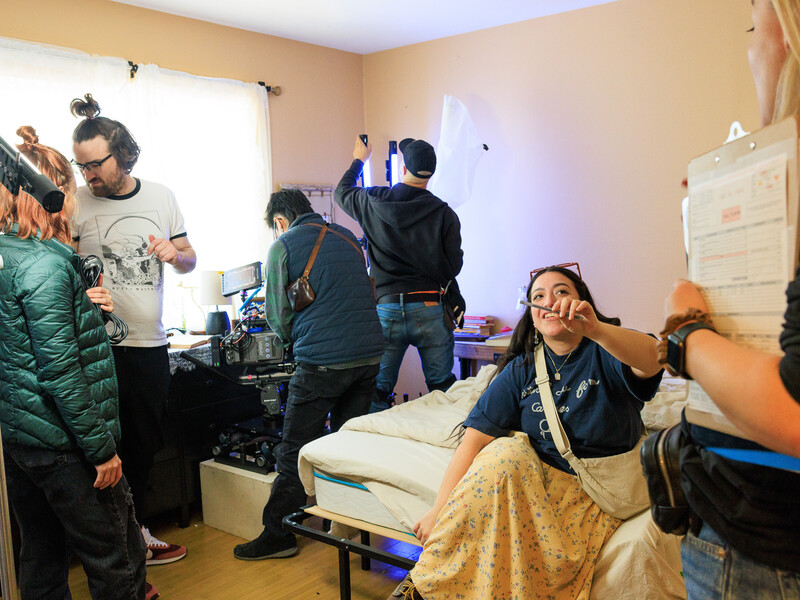 People in a room with filming equipment working on various tasks