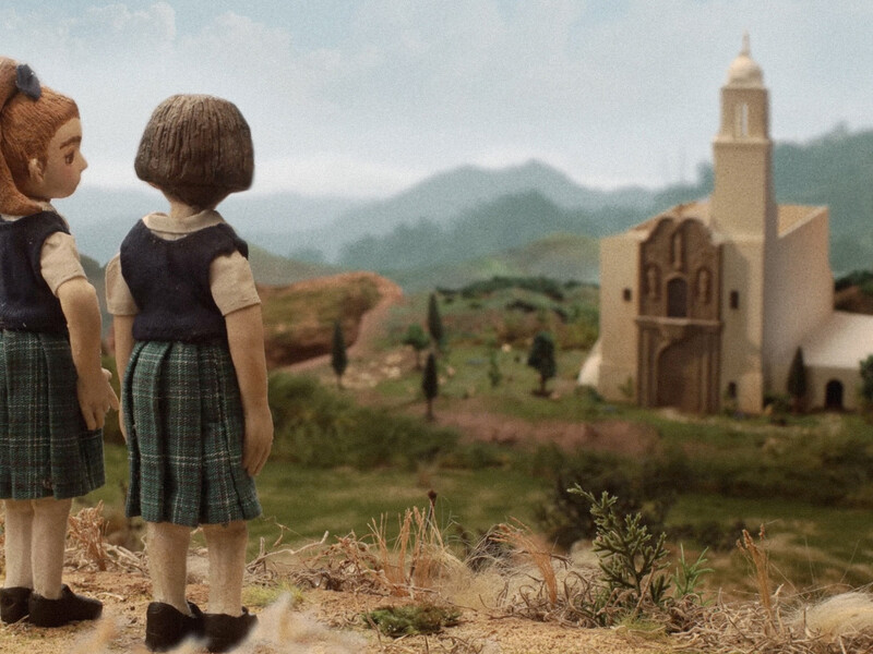 Two stop-motion characters looking over a hill at a building below