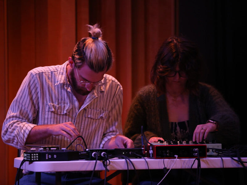 a couple intently plays a sound board