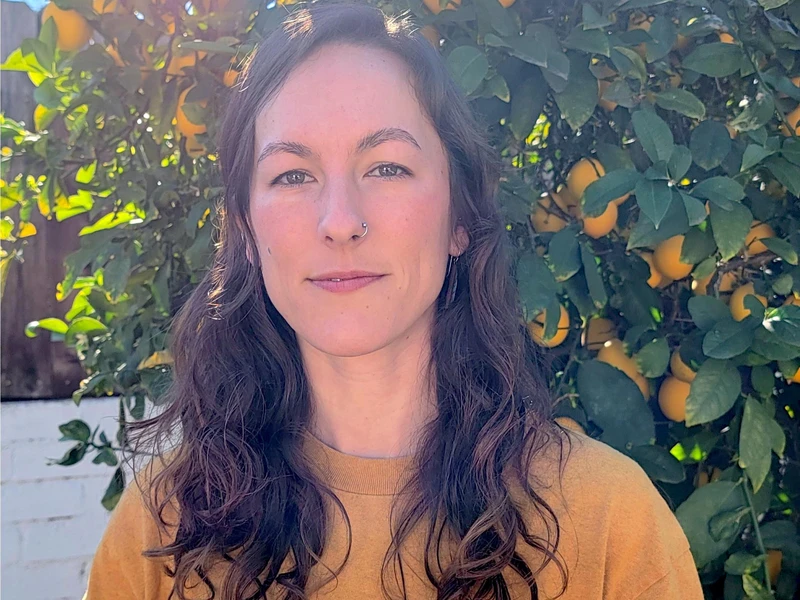 Photo of Simone Larson Zapata in front of a lemon tree / plant