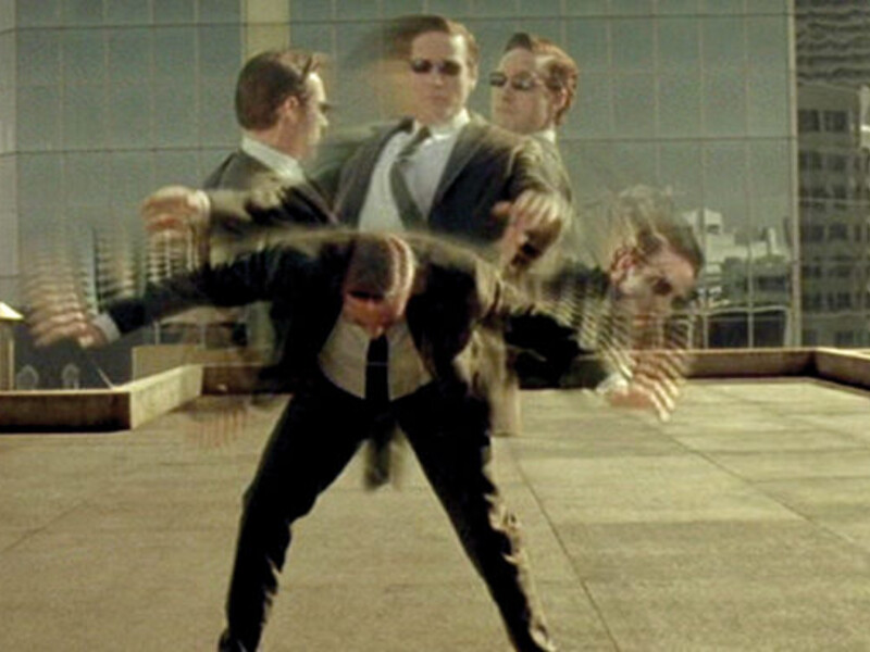 Still shot of a character from the movie, "The Matrix". A visual of a man moving so fast he dodges bullets. The frame shows bullet time, displaying the man is fast enough to dodge the bullet. The frame shows the man's upper body in 5 different positions, while his legs remain still. 