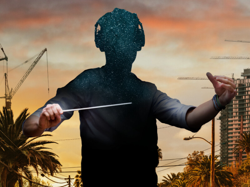 Silhouette of a conductor filled with stars, set against a sunset cityscape with cranes and palm trees.