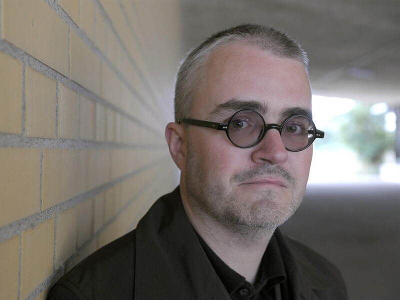 Headshot of Volker Straebel with a brick wall in the background