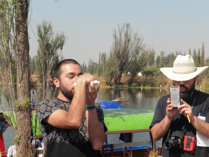 Lost river class at CalArts, featuring a student drinking water in front of a lake while another student looks on