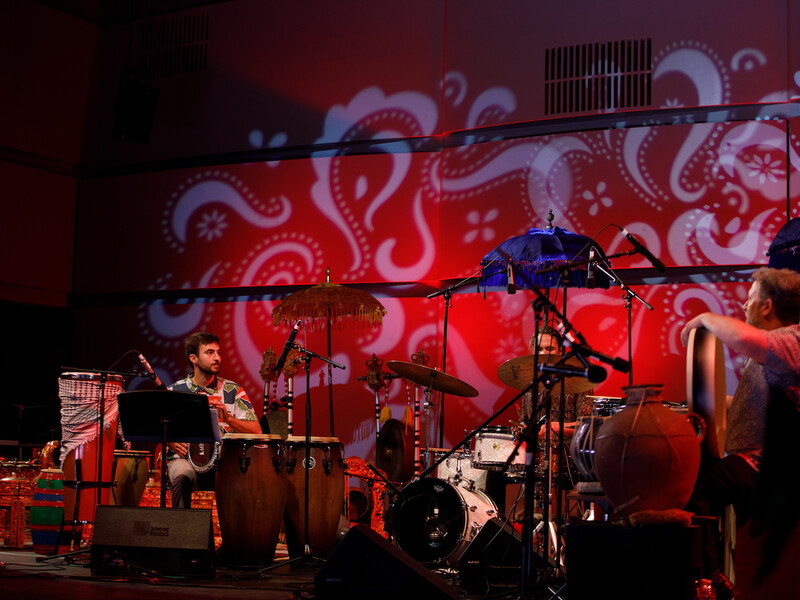 World percussion ensemble performs on a red stage at CalArts