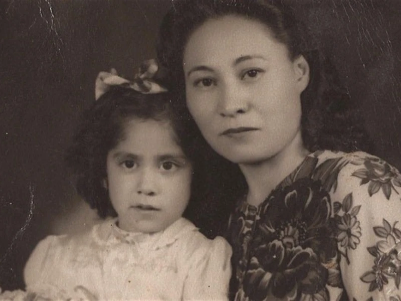 Black and white portrait of two people with a dark background.