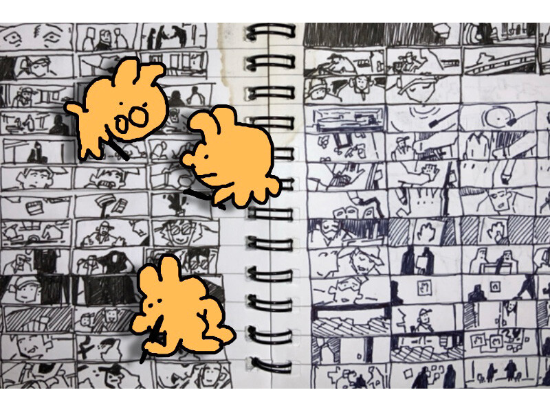 Spiral notebook with hand-drawn sketches and three cartoonish orange doodles.