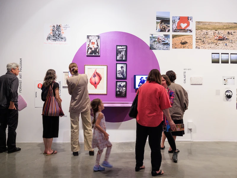 People at REDCAT look at a wall of art in a museum. 