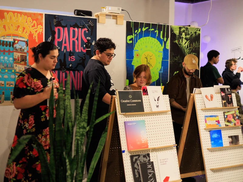 CalArts grahic design poster show audience looks at works in the show.