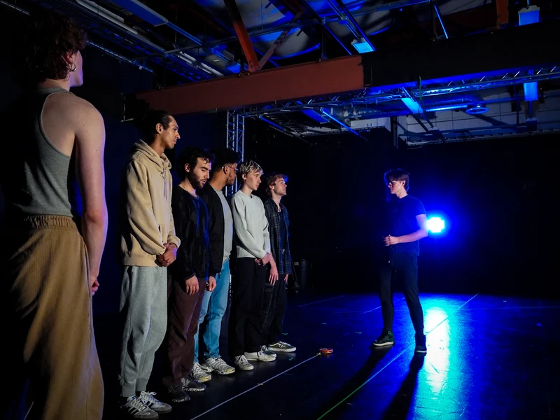 CalArts Theater performers stand on stage suring reharsal for Danton's Death