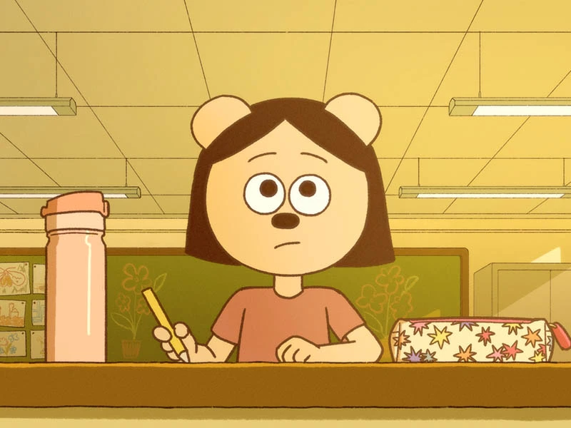 Cartoon character at a classroom desk with a pencil.