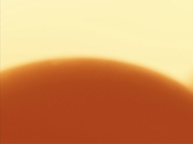 A close-up of a gradient with a deep orange semicircle against a bright yellow background.