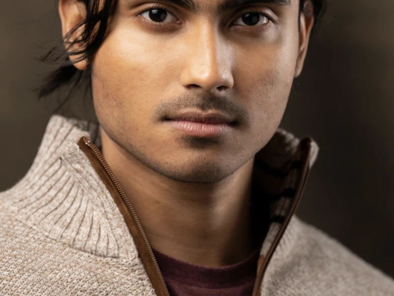 Person in a brown sweater stares directly into the camera.