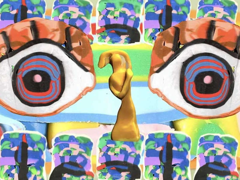 A surreal image with two large eyes and a gold abstract shape on a colorful, patterned background.