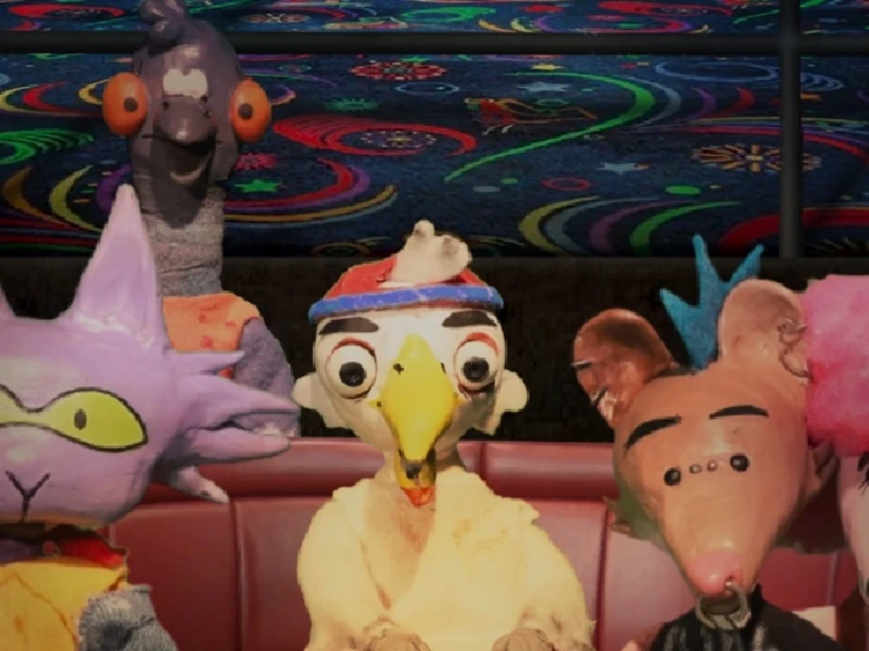 Five colorful puppet characters sit in a red booth, against a vibrant, swirling-patterned background.