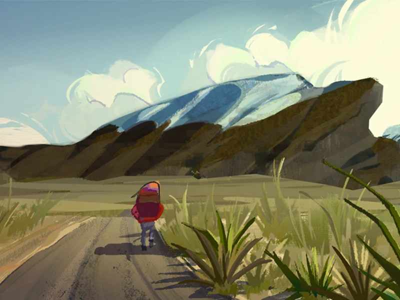 Person walking on a dirt path towards snow-capped mountains beneath a clear sky.