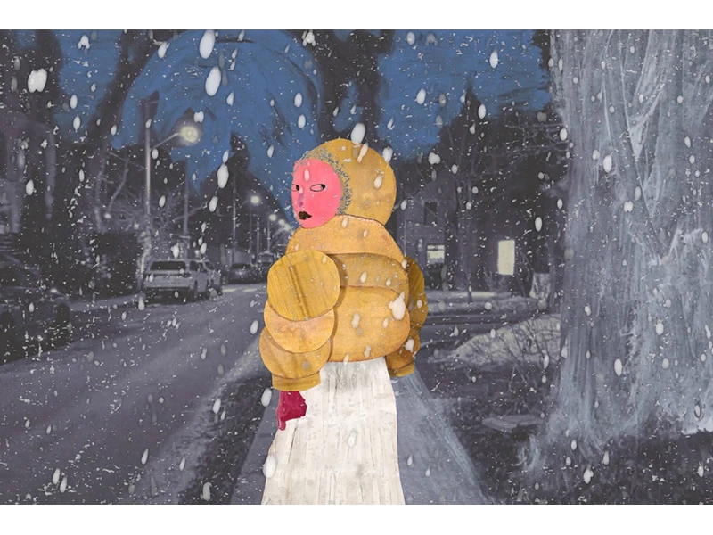 A figure in a yellow puffy jacket stands in the snow on a suburban street at night.