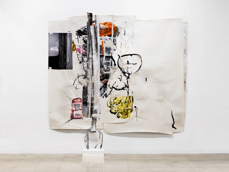 Mixed-media artwork with paper, painted elements, and a vertical dark strip displayed on a white wall.