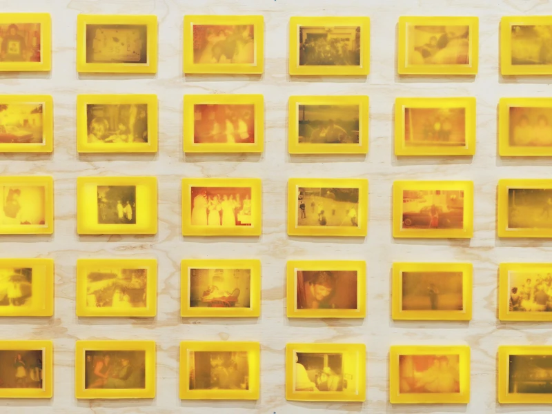 A grid of 30 vintage photographic slides with yellow borders on a wooden background.